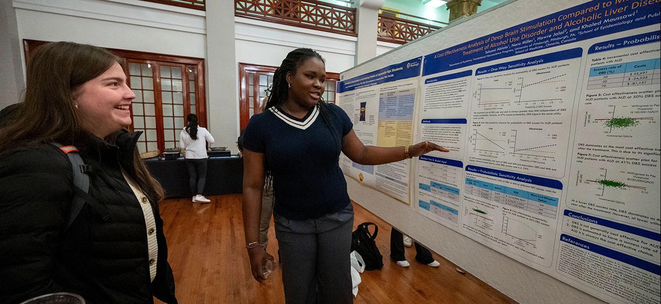 student shares research poster during Undergraduate Research and Creative Expression Fair at Pitt